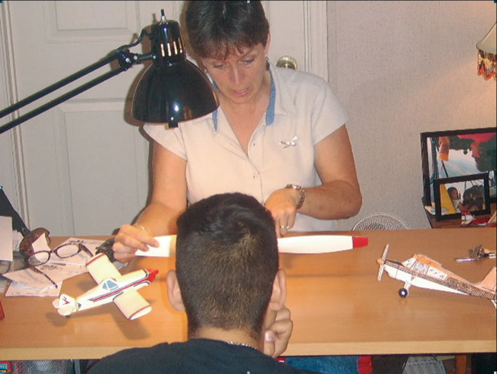 Figure 4-1. An aviation instructor communicates with her learner using model airplanes to ensure the learner’s understanding of the principles discussed.