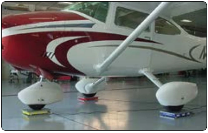 Figure 6-18. A Cessna 182 being weighed with portable electronic platform scales.
