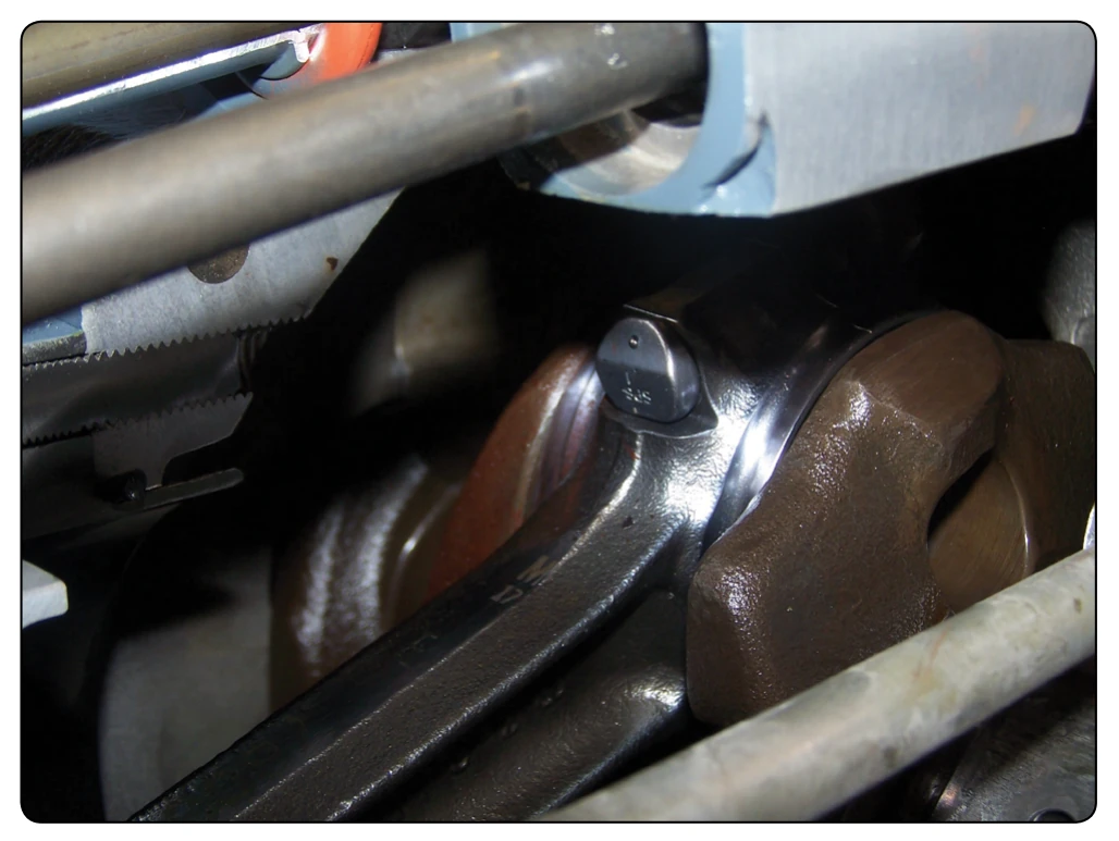 A connecting rod between the piston and crankshaft.