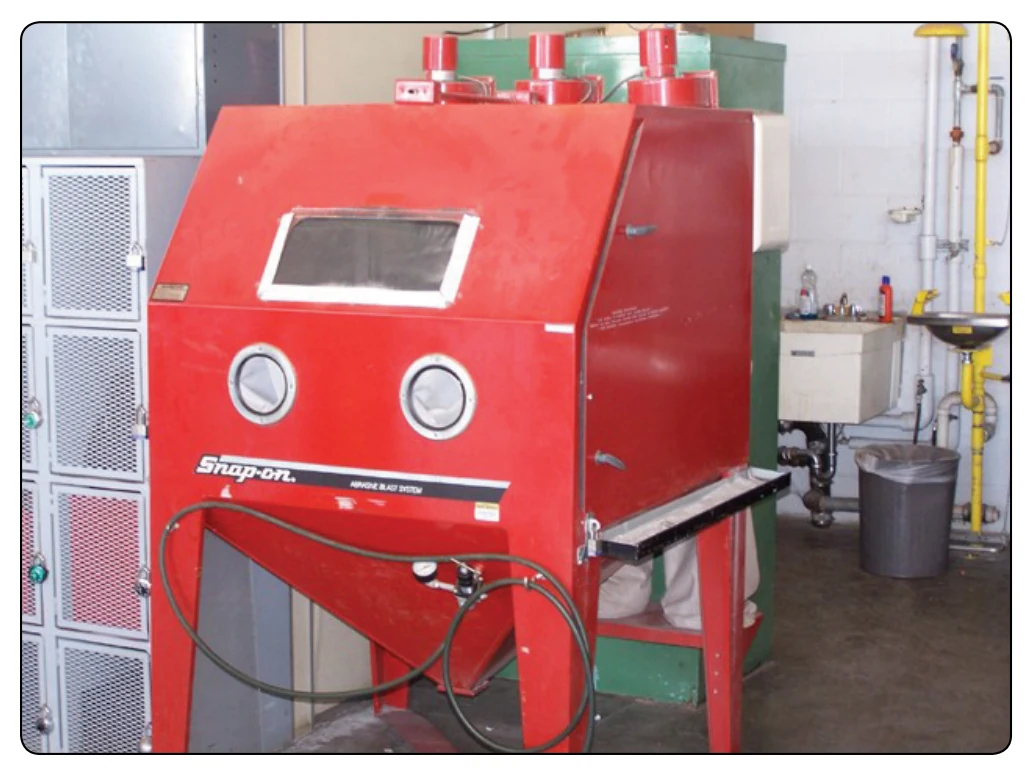 Grit-blasting machine.