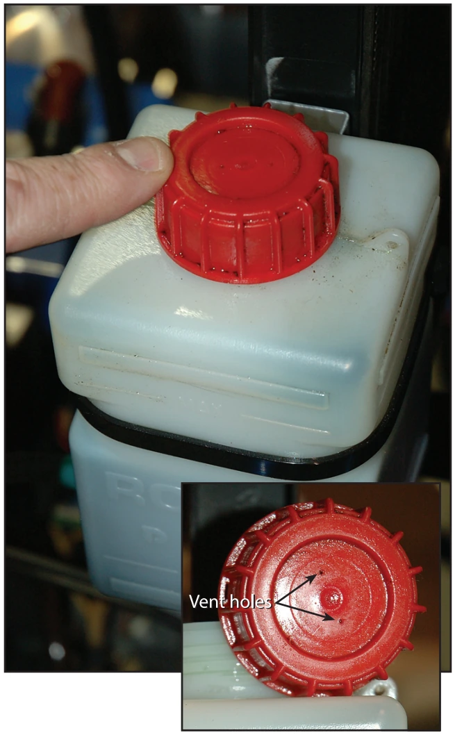 Figure 5-10. It is important to check the oil reservoir cap to make sure the vent holes are open and free of debris.