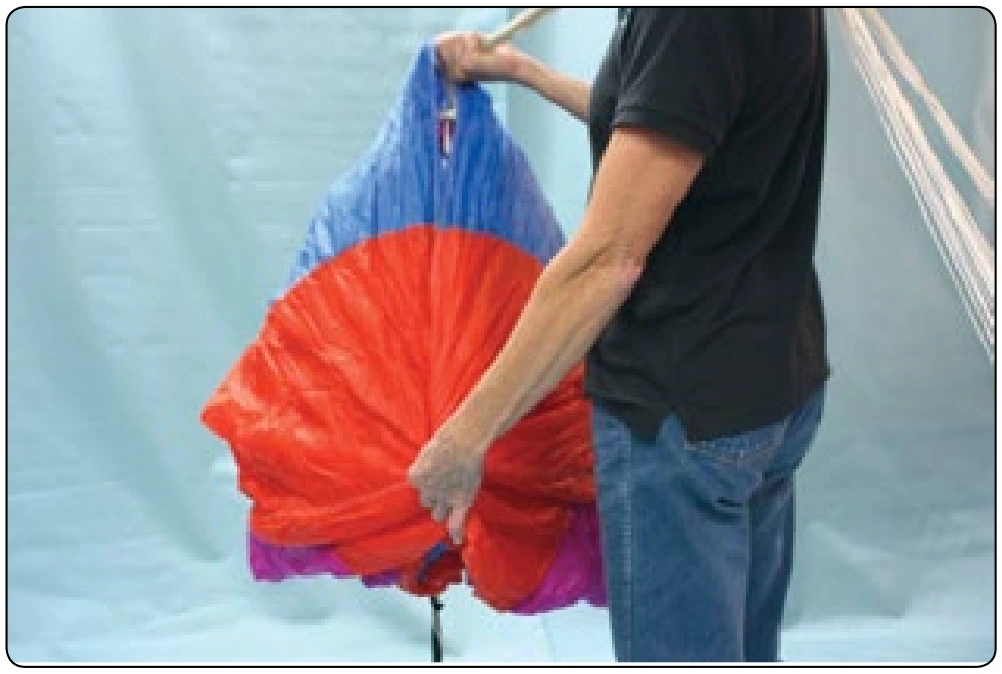 Figure 4-14. Roll the tail to prevent the canopy from splaying out when it is laid down on the ground. Be sure to prevent the upper control lines from coming around to the nose of the canopy. Keep them centered and back.