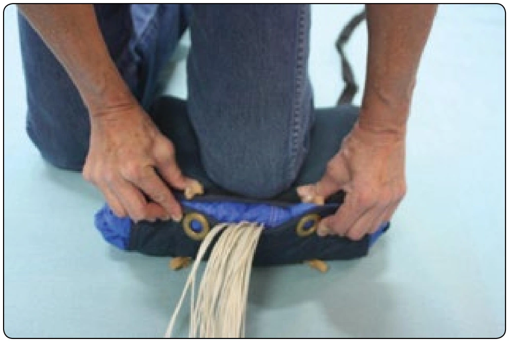 Figure 4-29. The closing flap of the bag is pulled so that the grommets meet the rubber bands. You should not have to stretch the rubber bands very far.