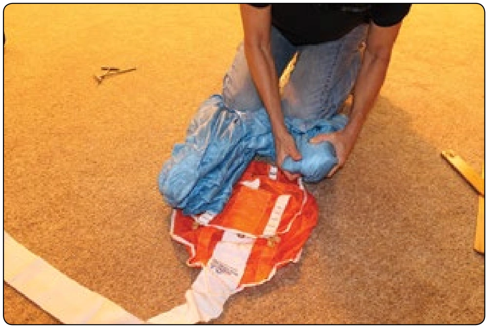 Figure 5-137. Fold the ears under and pull the bag over the canopy.