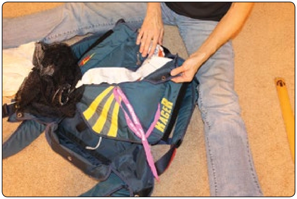 Figure 5-153. Insert bodkin through the top grommets of the backpad and bag and close upper side flap. There should be little or no canopy fabric in this upper area if good division of the ears has been maintained.