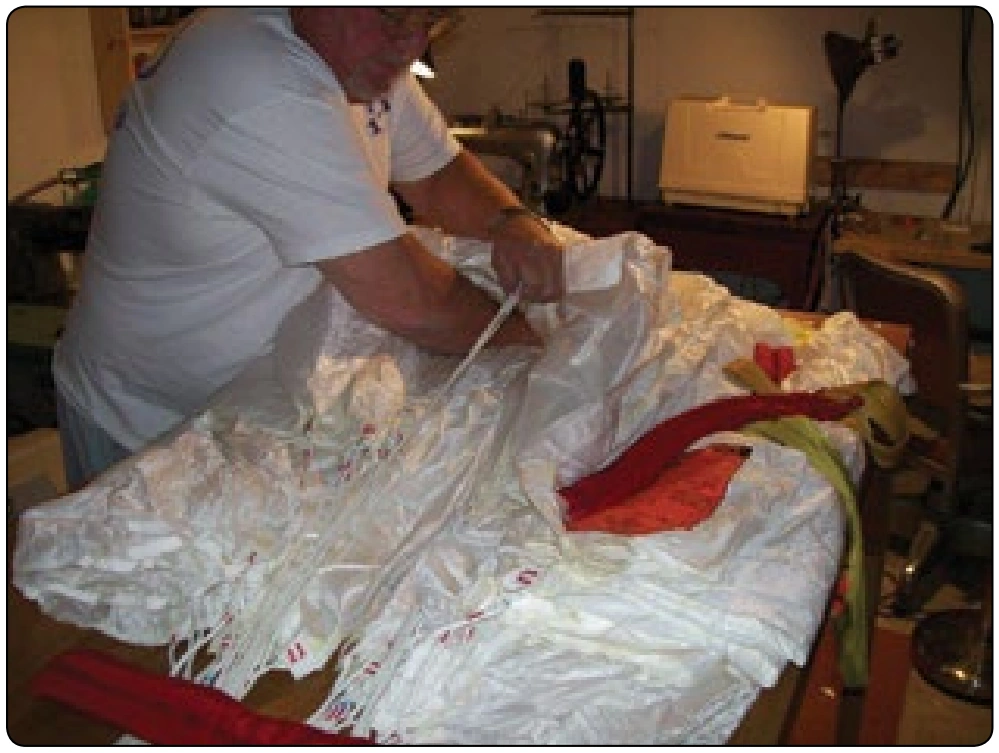 Figure 6-87. A square canopy being packed on a table, which must be accessible from both sides of the table in order to inspect and fold it properly.