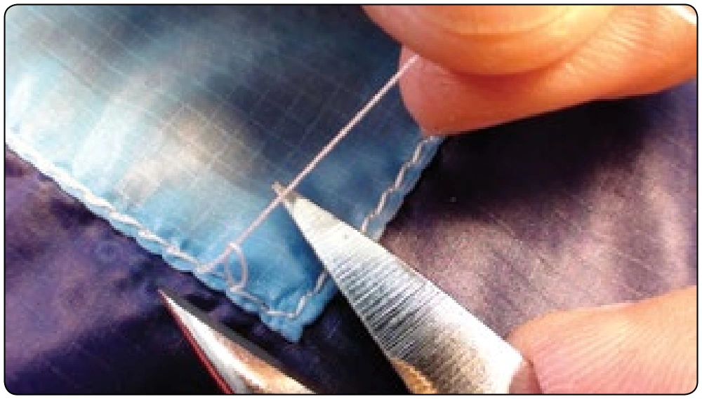 Figure 7-31. If you pull up sharply on the top thread, the bottom thread will form a loop allowing you to cut both at once and remove the bottom thread through the fabric.