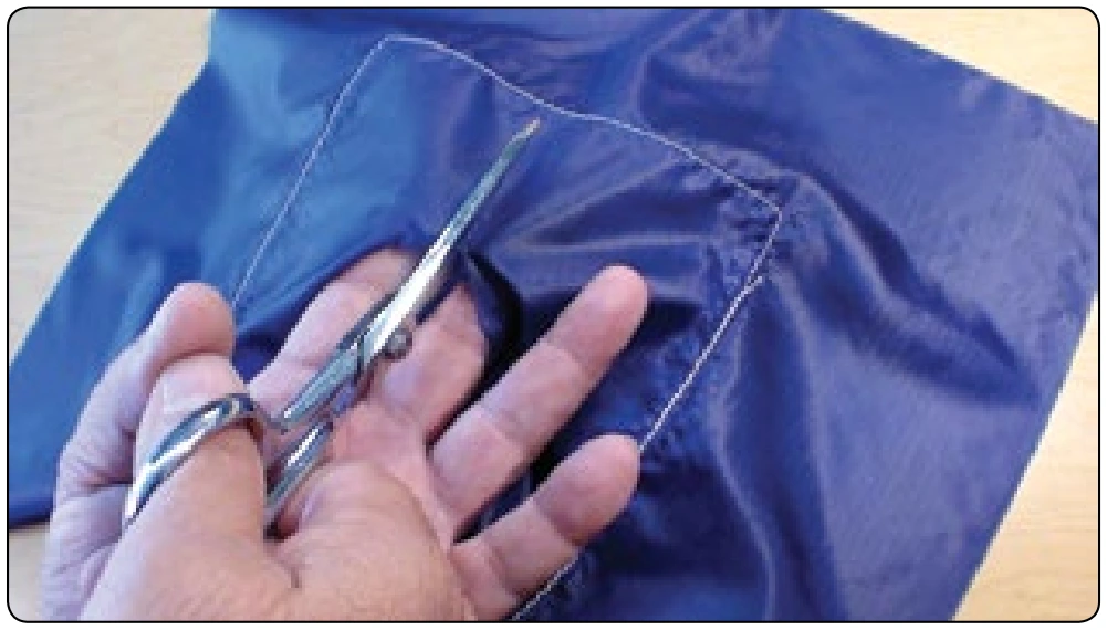 Figure 7-32. Wear the damaged parachute as if it were a mitten while cutting and you will not cut the patch that was just carefully placed.